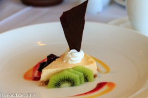 House made Cheese cake with Kiwi and blackberry coulis, topped with dollop of fresh whipped cream and rich chocolate